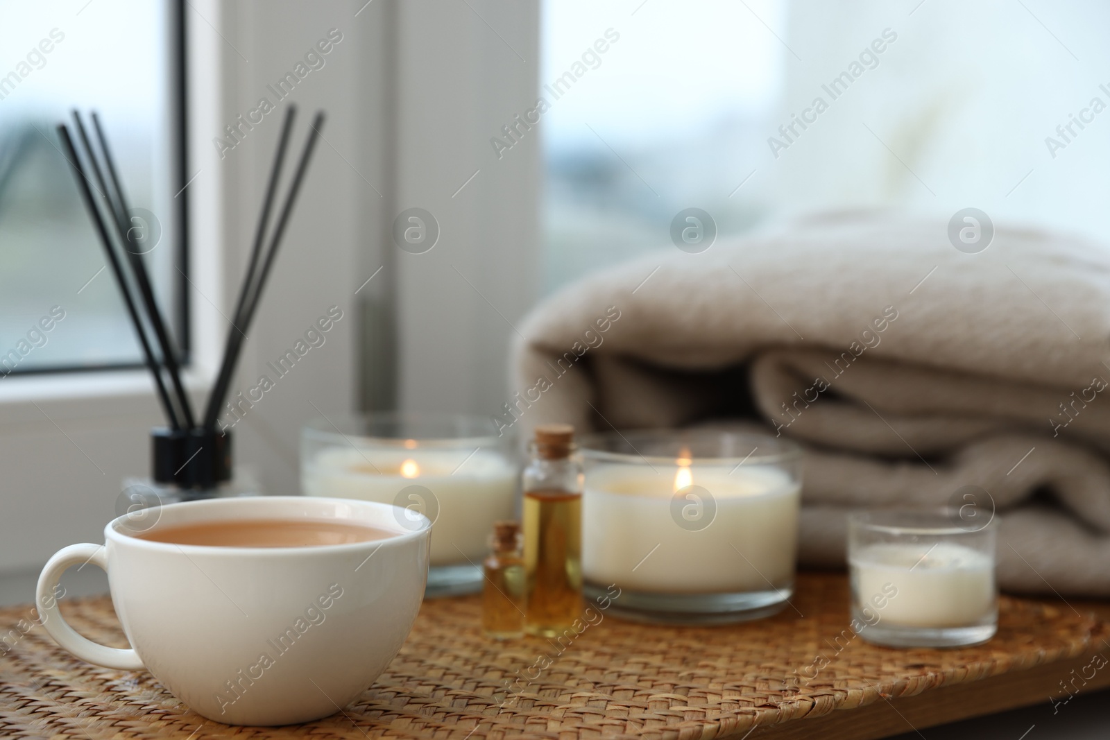 Spa composition with burning candles and reed air freshener on windowsill, selective focus Photo of Spa composition with burning candles and reed air freshener on windowsill, selective focus