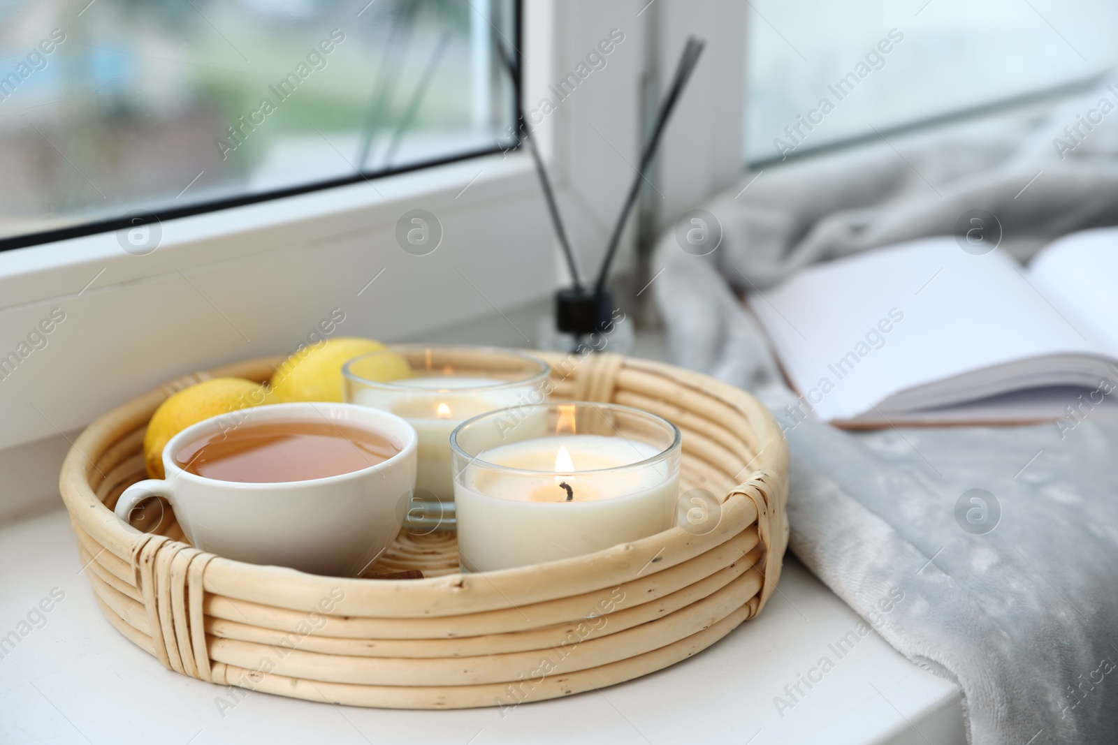 Spa composition with burning candles and reed air freshener on windowsill, closeup Photo of Spa composition with burning candles and reed air freshener on windowsill, closeup