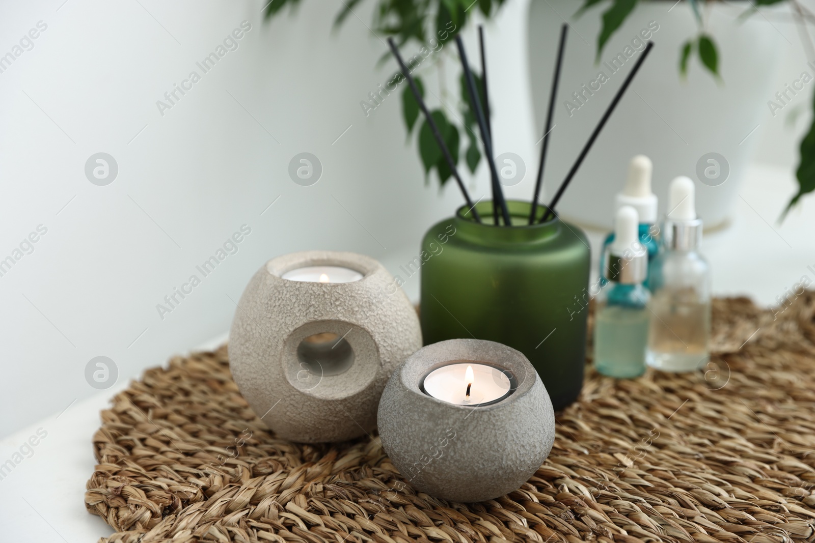 Spa composition with burning candles and reed air freshener on table indoors, closeup Photo of Spa composition with burning candles and reed air freshener on table indoors, closeup
