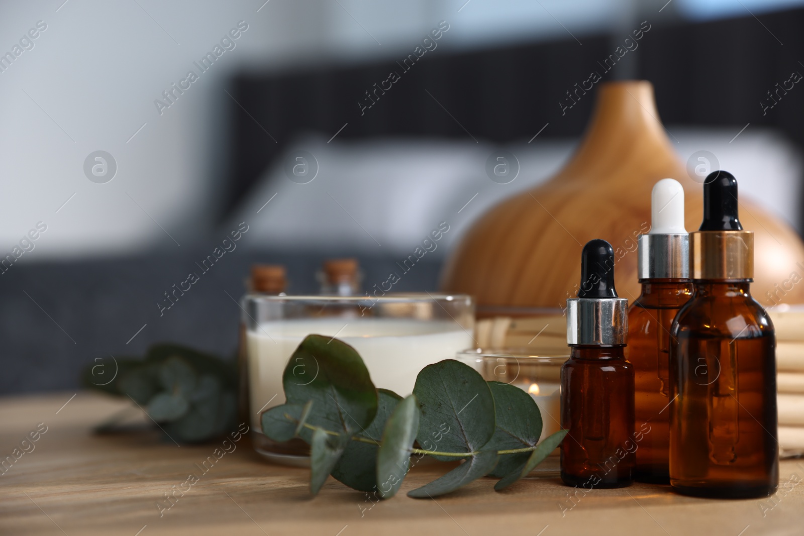 Spa composition with aroma oil diffuser and burning candles on wooden table, closeup Photo of Spa composition with aroma oil diffuser and burning candles on wooden table, closeup