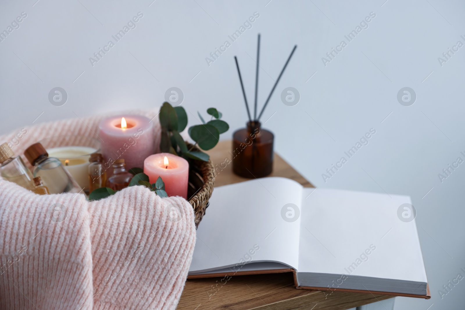 Spa composition with burning candles and reed air freshener on wooden table indoors, closeup Photo of Spa composition with burning candles and reed air freshener on wooden table indoors, closeup