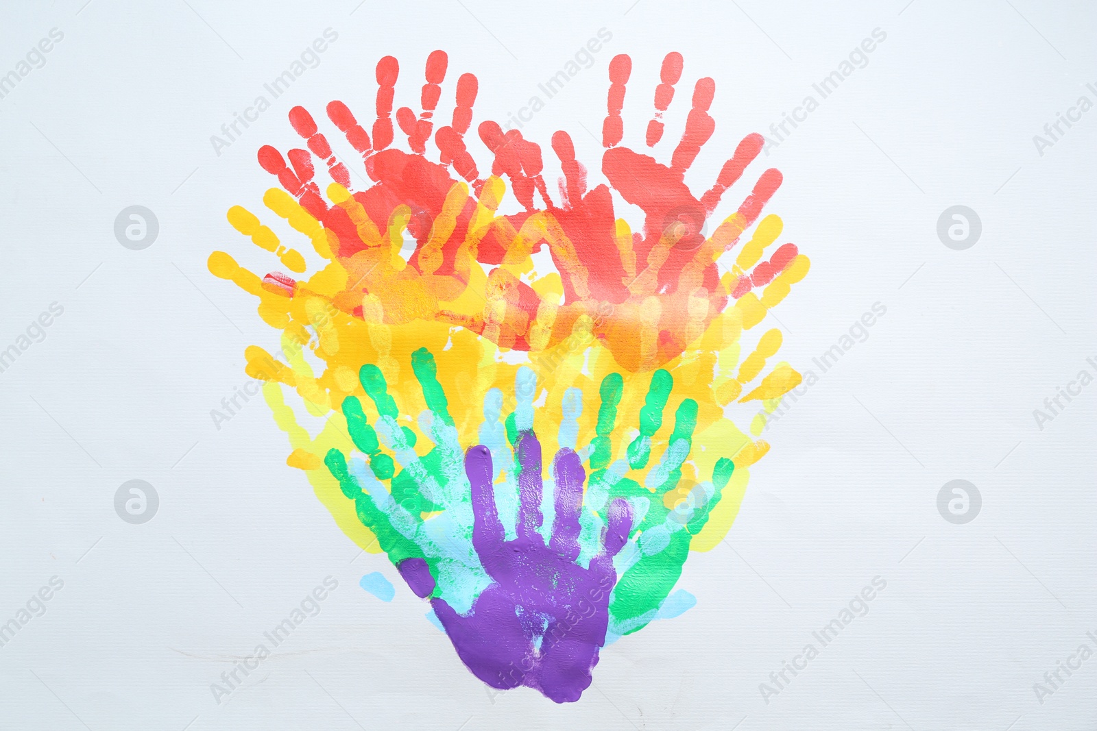 Tolerance concept. Heart of colorful handprints on white background, top view Photo of Tolerance concept. Heart of colorful handprints on white background, top view