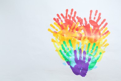 Photo of Tolerance concept. Heart of colorful handprints on white background, top view. Space for text