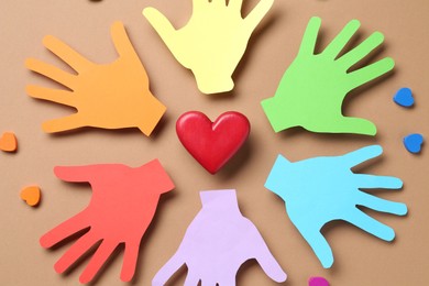 Photo of Tolerance concept. Colorful paper hands and hearts on brown background, flat lay