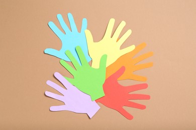 Photo of Tolerance concept. Colorful paper hands on brown background, flat lay
