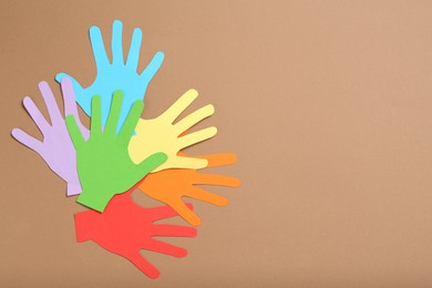 Photo of Tolerance concept. Colorful paper hands on brown background, flat lay. Space for text