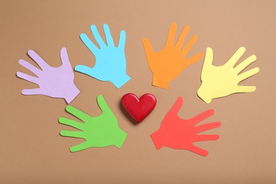 Photo of Tolerance concept. Colorful paper hands and heart on brown background, flat lay