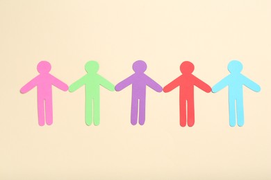 Photo of Tolerance concept. Colorful human figures on beige background, flat lay