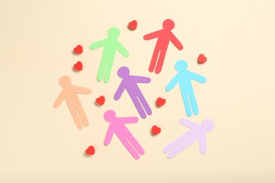 Photo of Tolerance concept. Colorful human figures and hearts on beige background, flat lay
