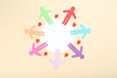 Photo of Tolerance concept. Colorful human figures and hearts on beige background, flat lay. Space for text
