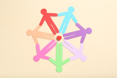 Photo of Tolerance concept. Colorful human figures and heart on beige background, flat lay