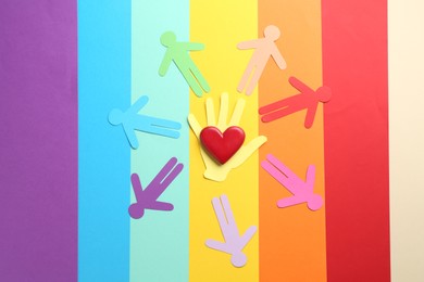 Photo of Tolerance concept. Paper human figures and heart on colorful background, flat lay