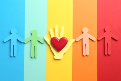 Photo of Tolerance concept. Paper human figures and heart on colorful background, flat lay