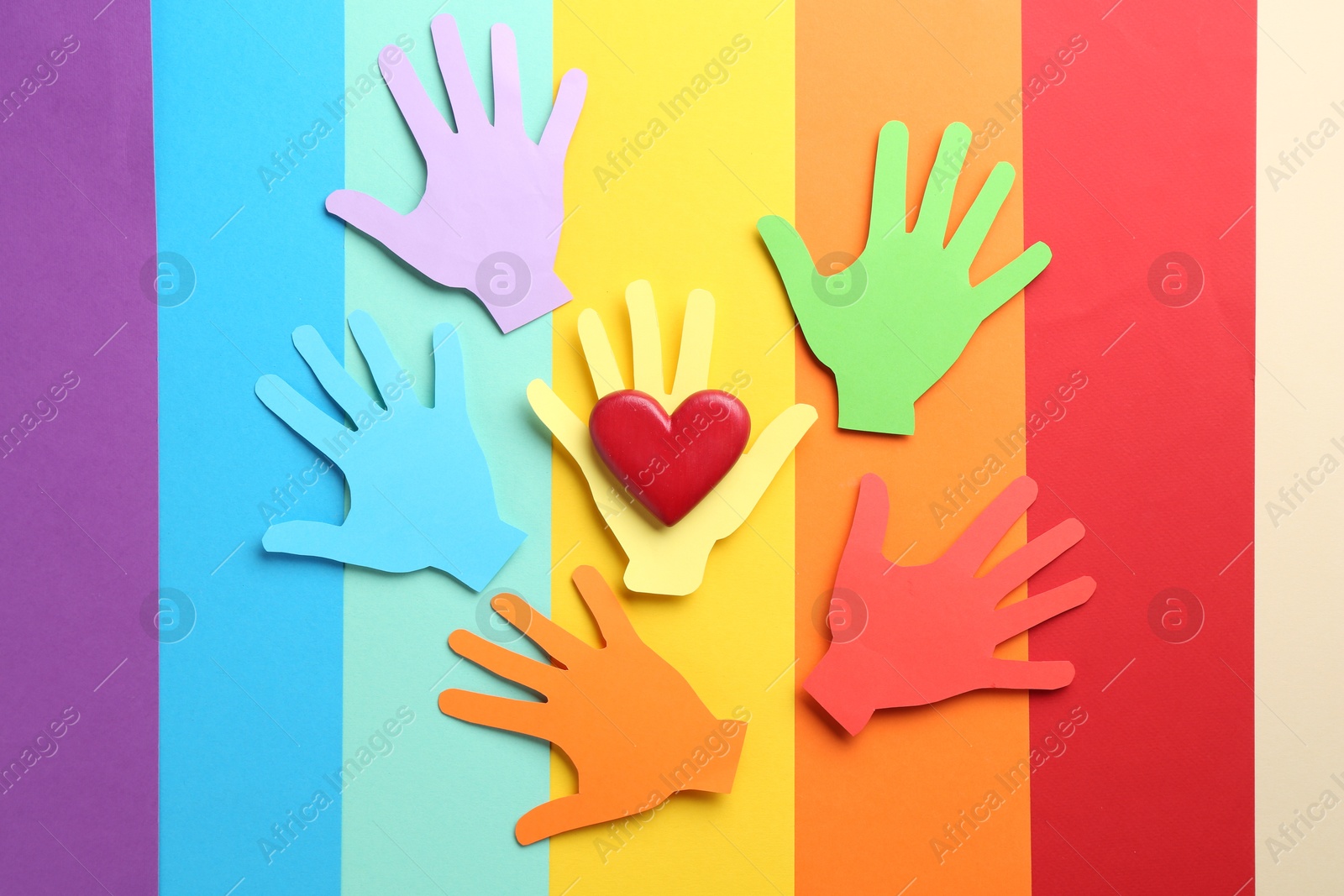 Tolerance concept. Paper hands and heart on colorful background, flat lay Photo of Tolerance concept. Paper hands and heart on colorful background, flat lay