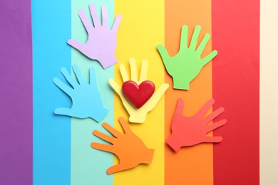 Photo of Tolerance concept. Paper hands and heart on colorful background, flat lay