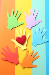 Photo of Tolerance concept. Paper hands and heart on colorful background, flat lay