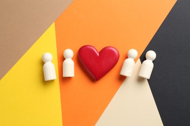 Photo of Tolerance concept. Human figures and heart on colorful background, flat lay