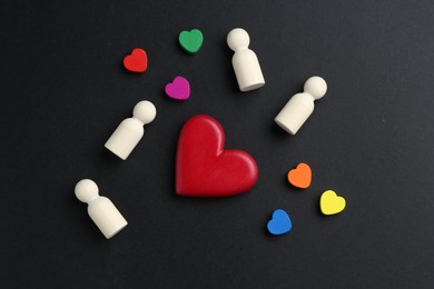 Photo of Tolerance concept. Human figures and colorful hearts on black background, flat lay
