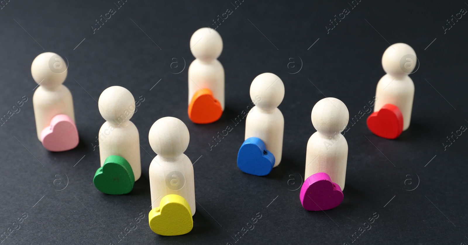 Tolerance concept. Human figures and colorful hearts on black background, closeup Photo of Tolerance concept. Human figures and colorful hearts on black background, closeup