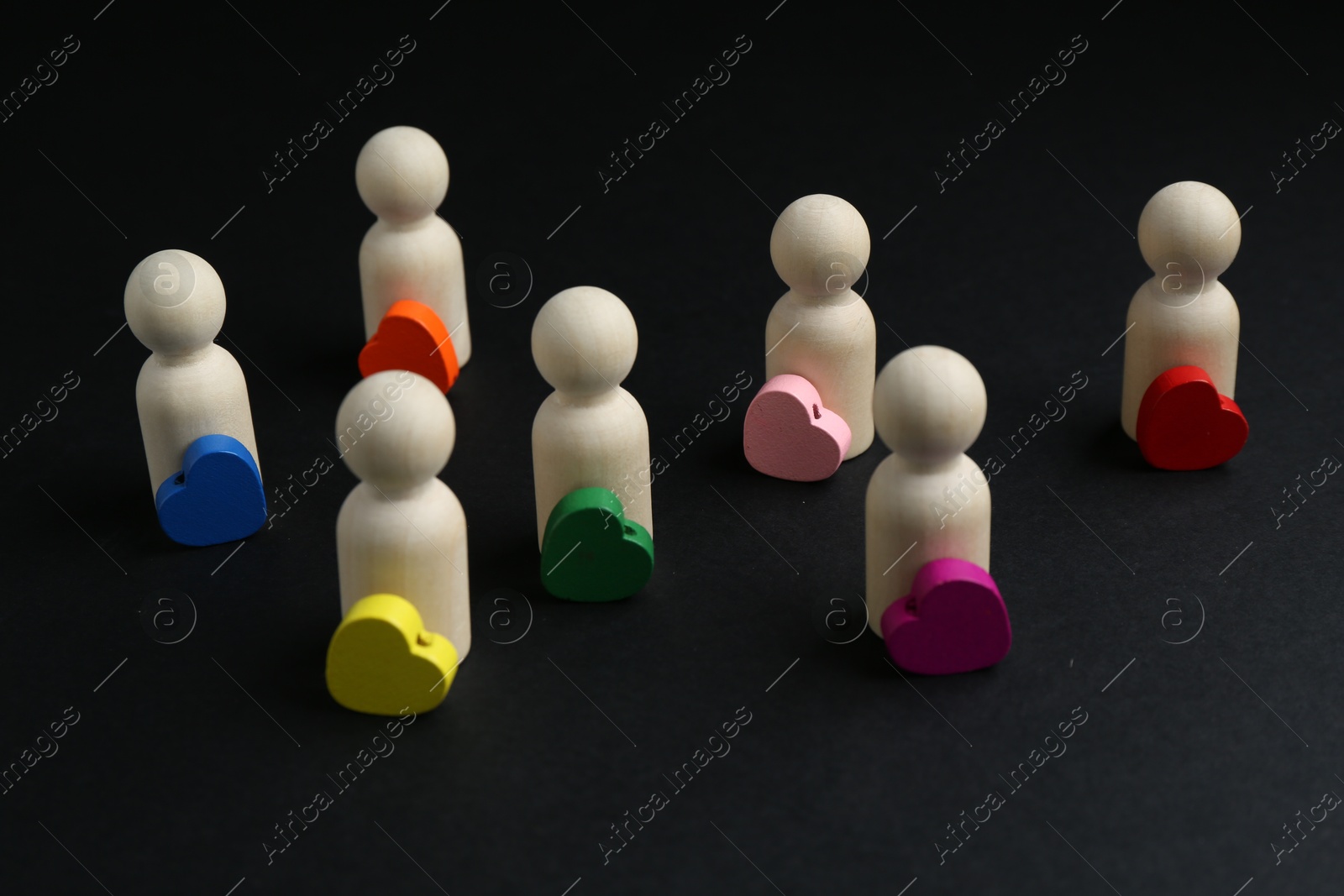 Tolerance concept. Human figures and colorful hearts on black background, closeup Photo of Tolerance concept. Human figures and colorful hearts on black background, closeup