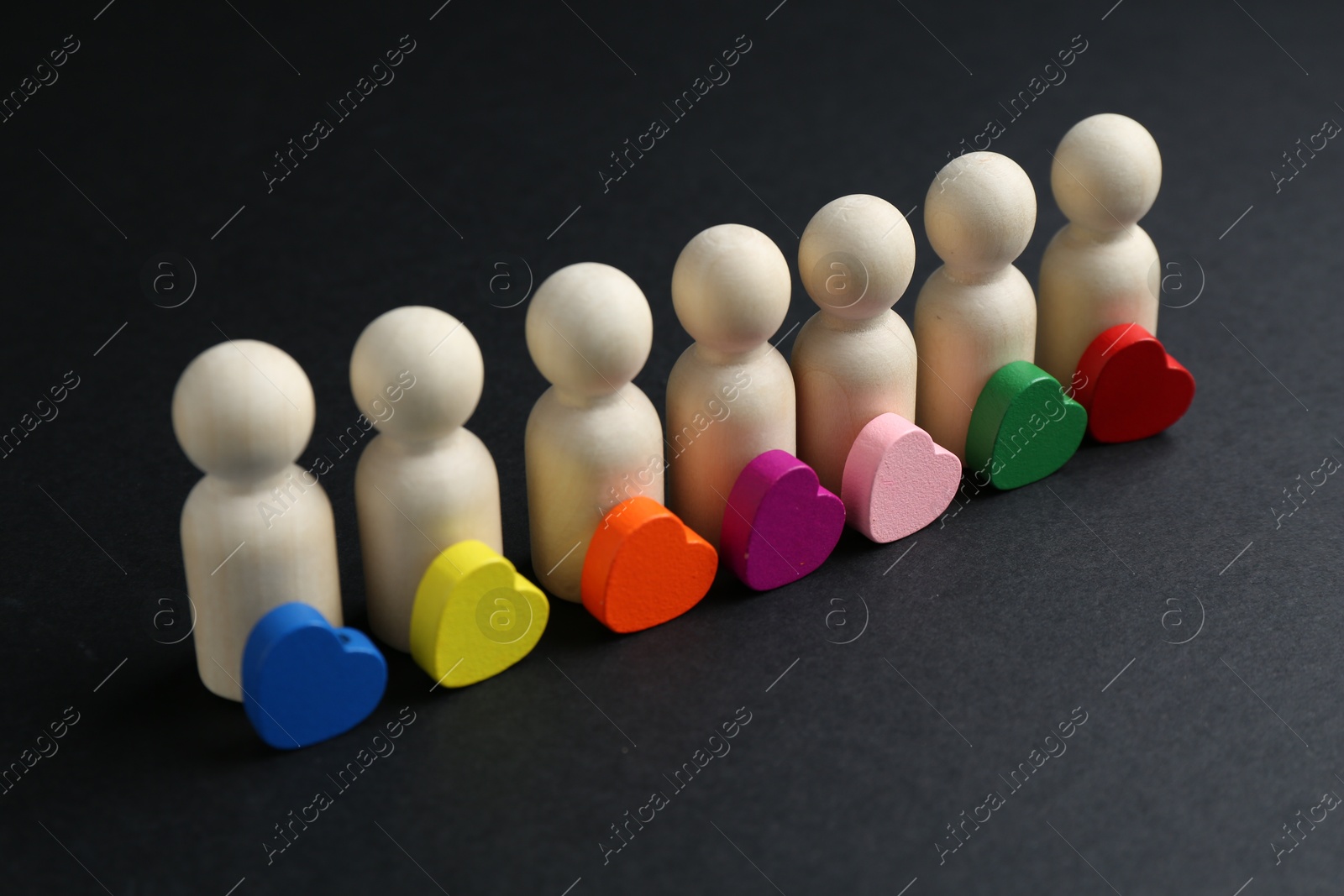 Tolerance concept. Human figures and colorful hearts on black background, closeup Photo of Tolerance concept. Human figures and colorful hearts on black background, closeup