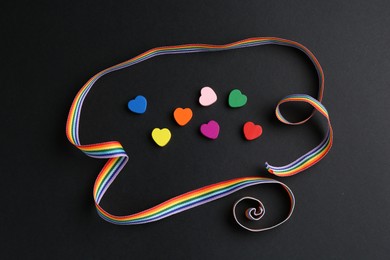 Photo of Tolerance concept. Colorful hearts and ribbon on black background, flat lay