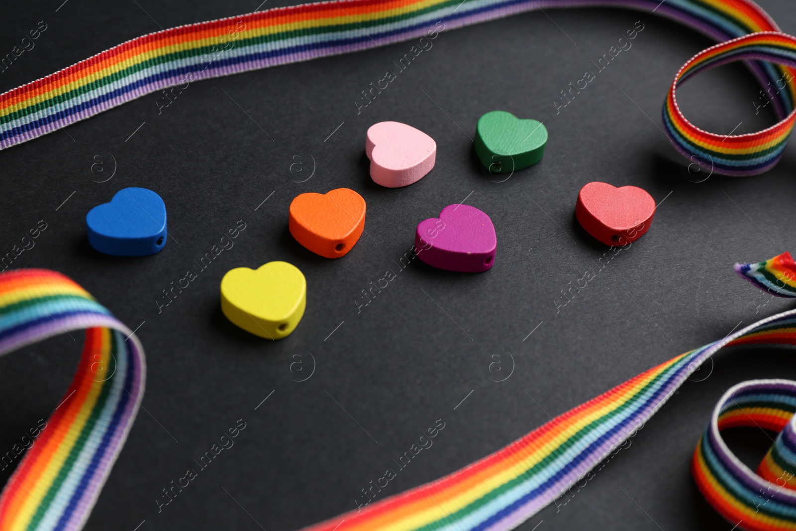 Tolerance concept. Colorful hearts and ribbon on black background, closeup Photo of Tolerance concept. Colorful hearts and ribbon on black background, closeup