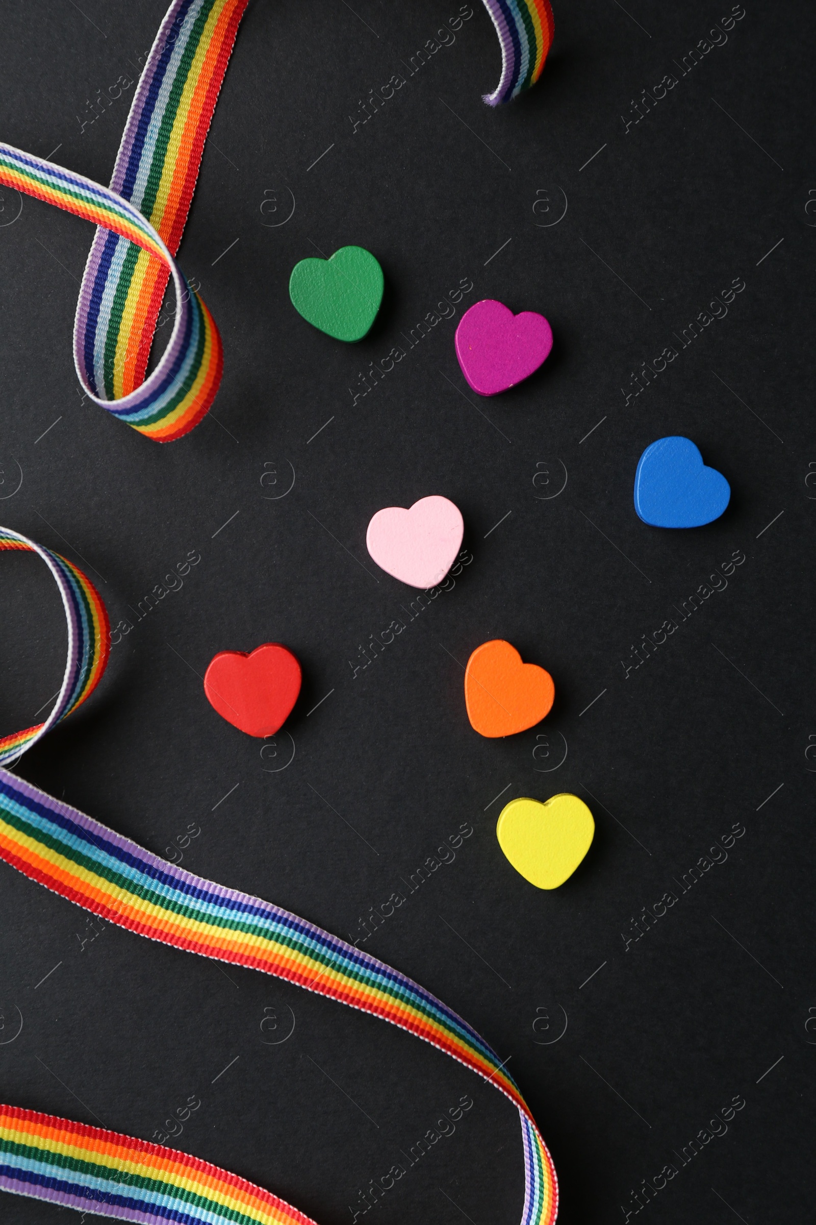 Tolerance concept. Colorful hearts and ribbon on black background, flat lay Photo of Tolerance concept. Colorful hearts and ribbon on black background, flat lay