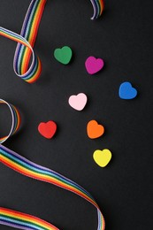 Photo of Tolerance concept. Colorful hearts and ribbon on black background, flat lay