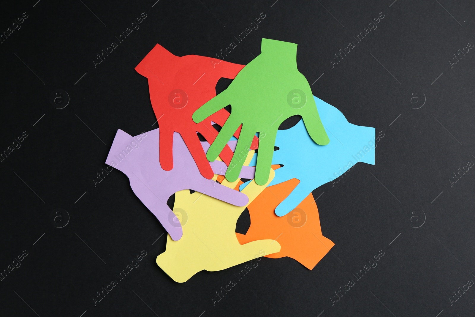 Tolerance concept. Colorful paper hands on black background, flat lay Photo of Tolerance concept. Colorful paper hands on black background, flat lay