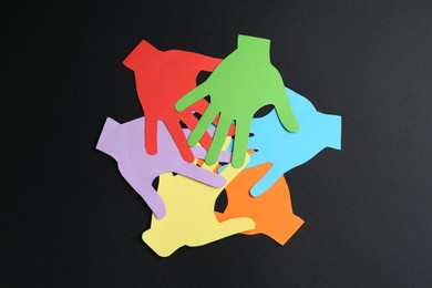 Photo of Tolerance concept. Colorful paper hands on black background, flat lay