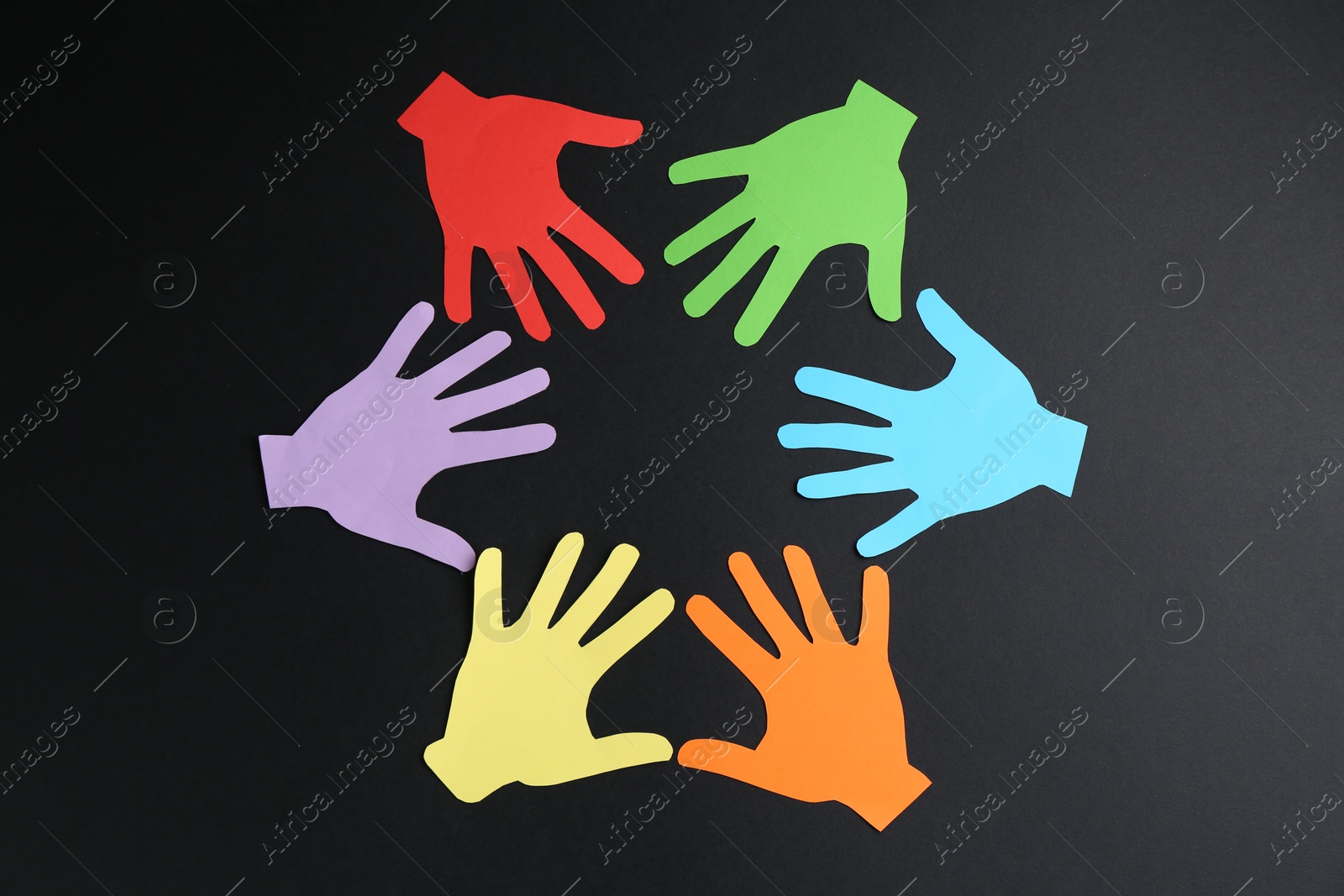 Tolerance concept. Colorful paper hands on black background, flat lay Photo of Tolerance concept. Colorful paper hands on black background, flat lay