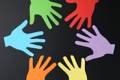 Photo of Tolerance concept. Colorful paper hands on black background, flat lay