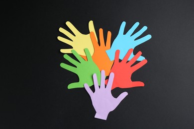 Photo of Tolerance concept. Colorful paper hands on black background, flat lay