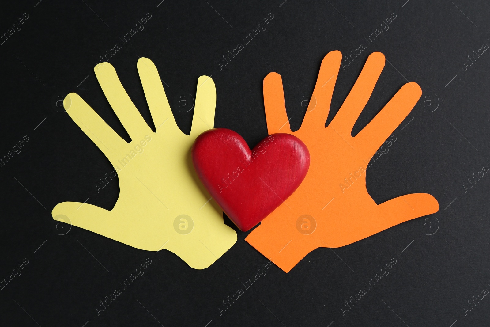 Tolerance concept. Colorful paper hands and heart on black background, flat lay Photo of Tolerance concept. Colorful paper hands and heart on black background, flat lay