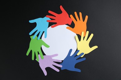 Photo of Tolerance concept. Colorful paper hands and empty card on black background, flat lay. Space for text