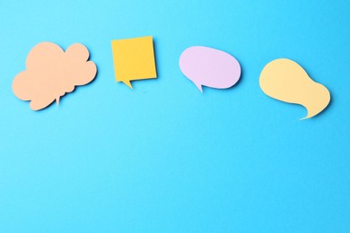 Photo of Tolerance concept. Speech bubbles on light blue background, flat lay. Space for text