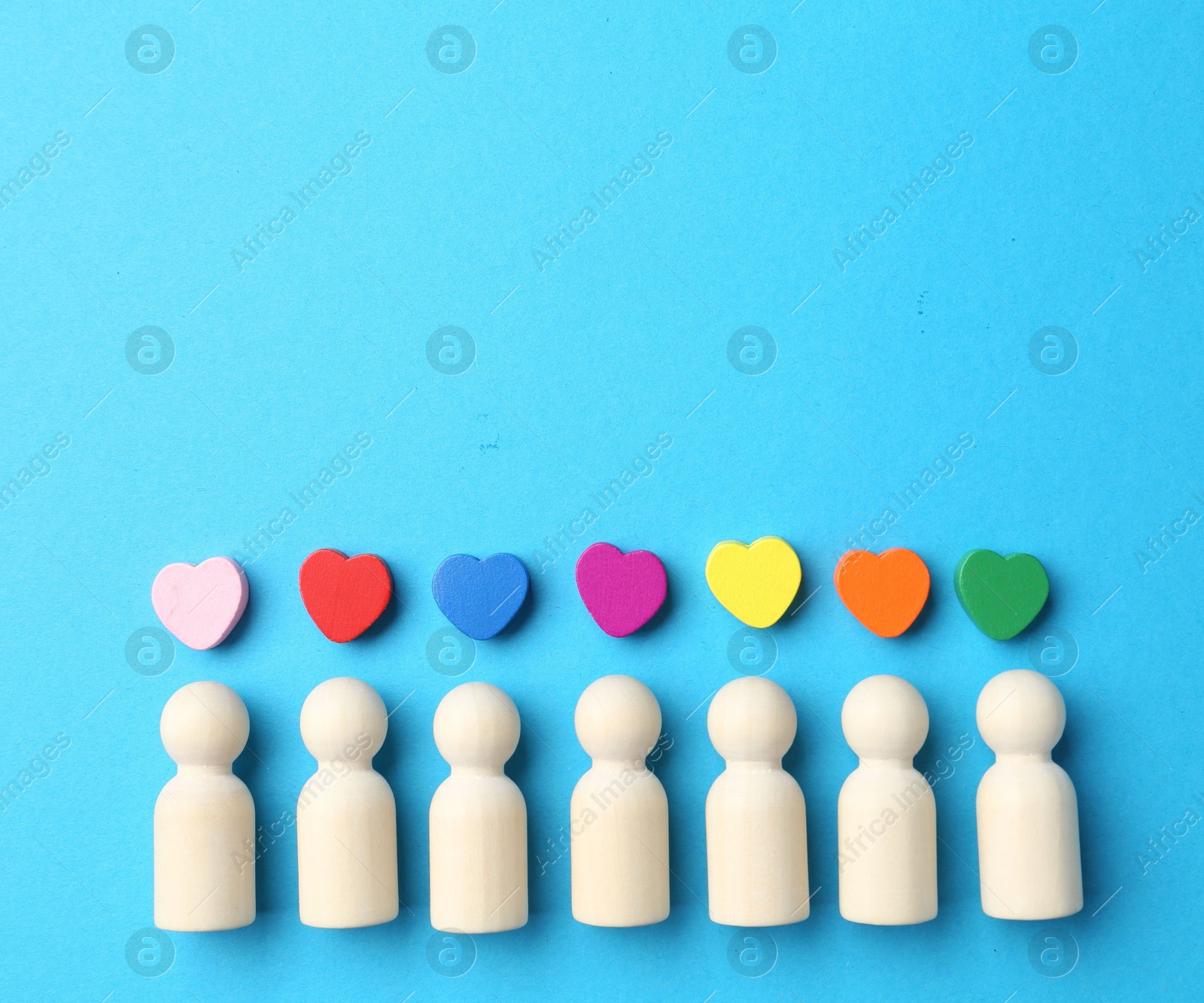 Tolerance concept. Human figures and colorful hearts on light blue background, flat lay. Space for text Photo of Tolerance concept. Human figures and colorful hearts on light blue background, flat lay. Space for text