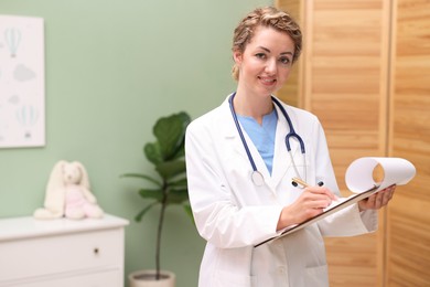 Photo of Pediatrician with clipboard in clinic. Space for text