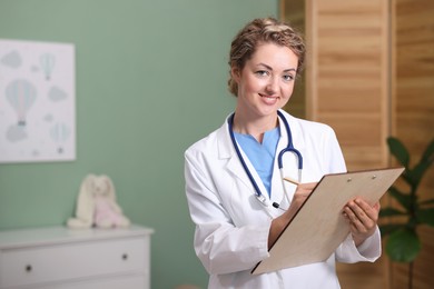 Photo of Pediatrician with clipboard in clinic. Space for text