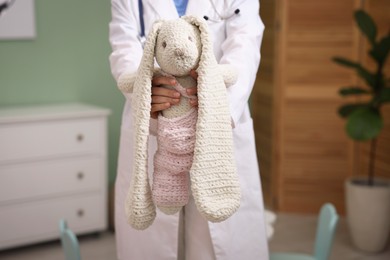 Photo of Pediatrician with toy bunny in hospital, closeup