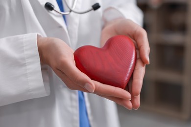Photo of Pediatrician with heart model in clinic, closeup