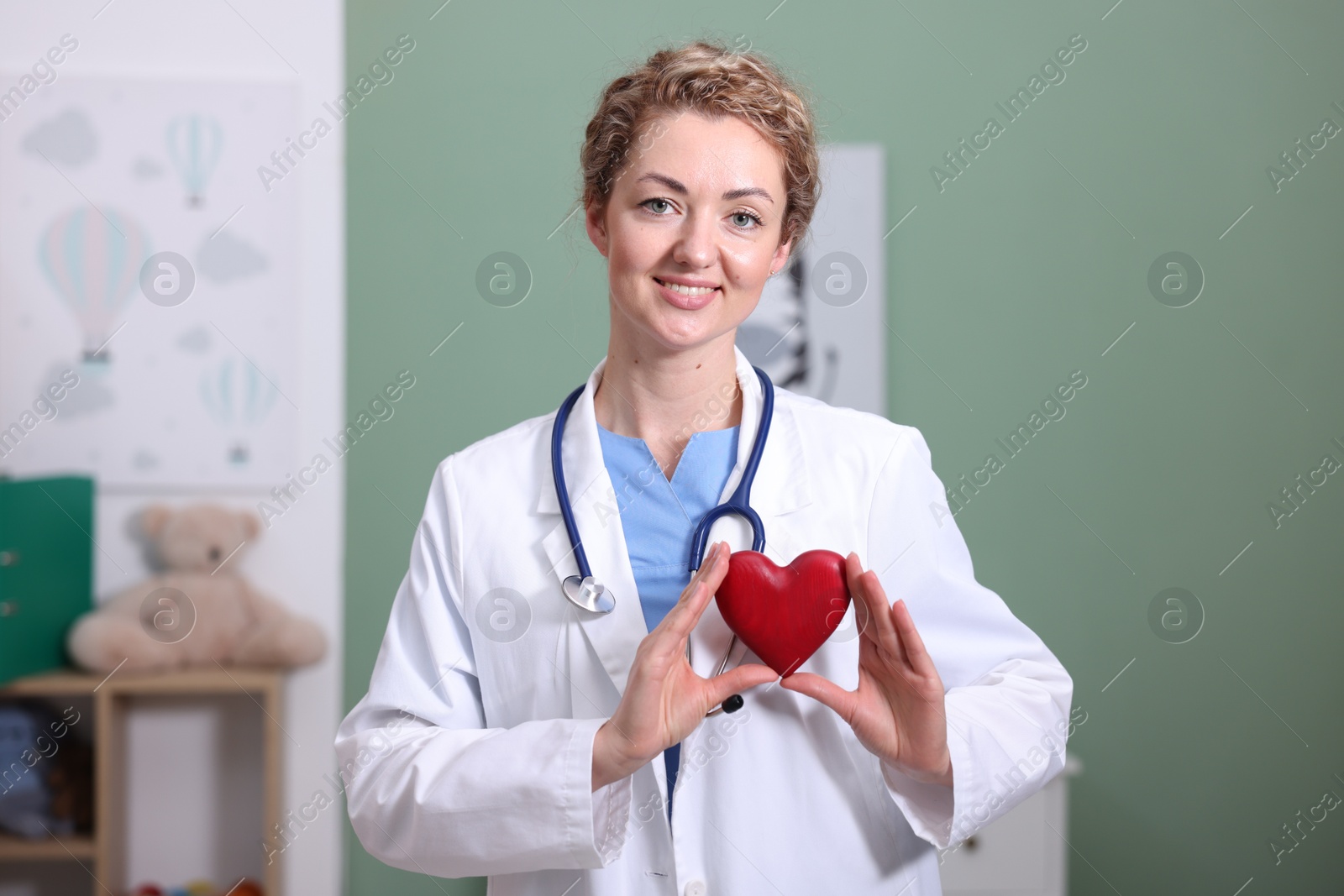 Professional pediatrician with heart model in clinic Photo of Professional pediatrician with heart model in clinic