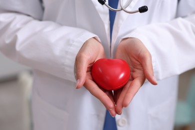 Photo of Pediatrician with heart model in clinic, closeup