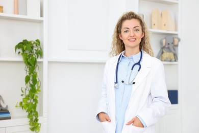 Photo of Portrait of professional pediatrician with stethoscope in hospital. Space for text