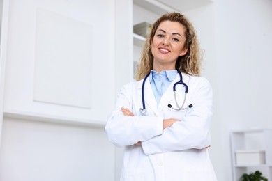 Photo of Portrait of professional pediatrician with stethoscope in hospital. Space for text