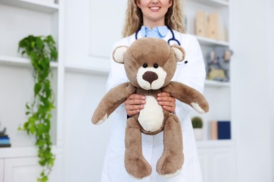 Photo of Pediatrician with toy bear in hospital, closeup