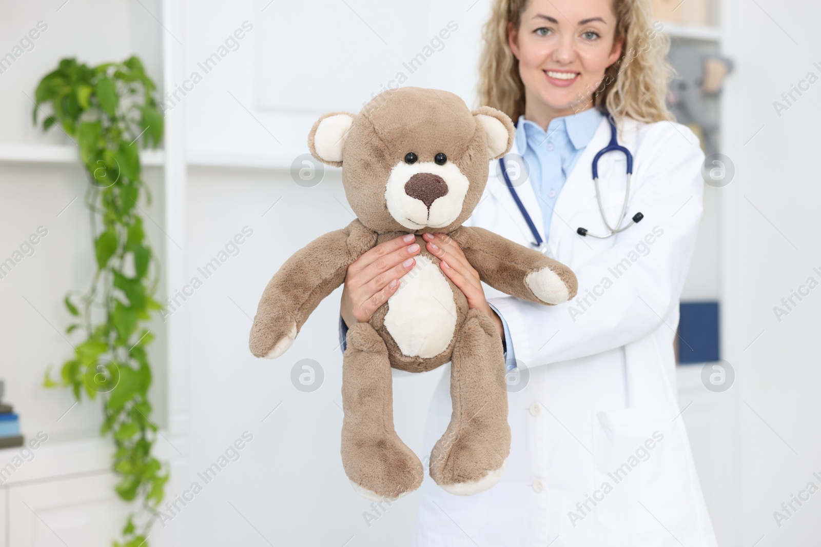 Pediatrician with toy bear in hospital, selective focus. Space for text Photo of Pediatrician with toy bear in hospital, selective focus. Space for text