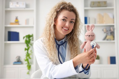 Photo of Pediatrician with toy bunny during video call, view from camera