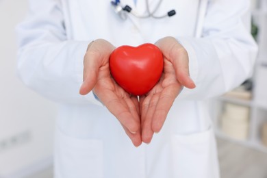 Photo of Pediatrician with heart model in clinic, closeup